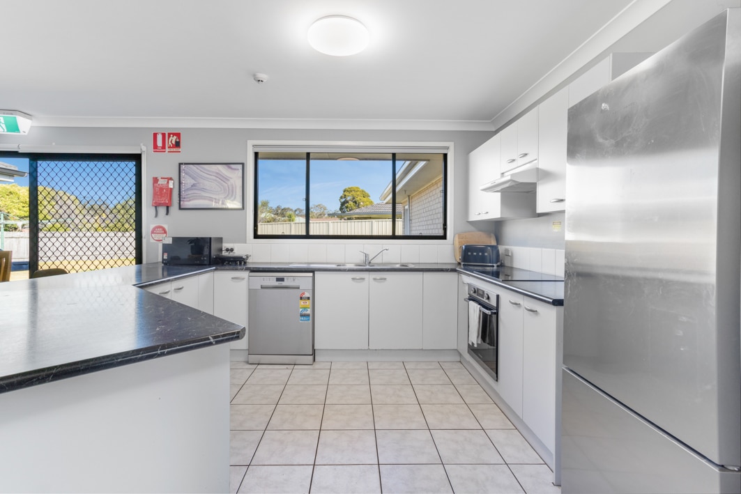 Large kitchen with white cabinets and modern stainless steel appliances.